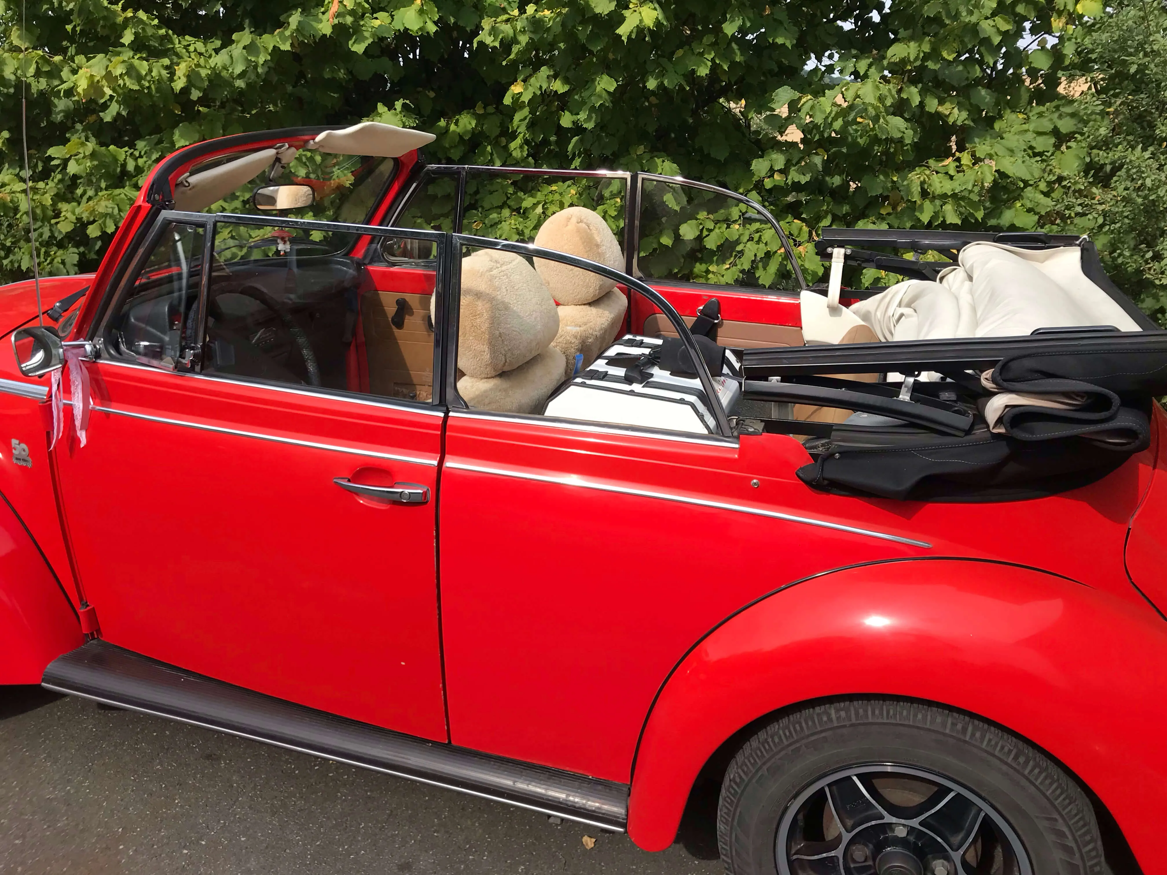 Paulibox in einem roten VW-Käfer-Cabrio